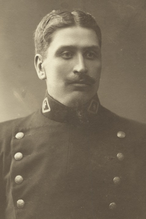 Porträtt föreställande ung polis med mustasch och uniform vid början av 1900-talet. 