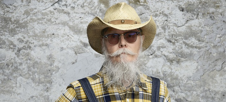 foto på man med grått skägg, solglasögon och cowboyhatt
