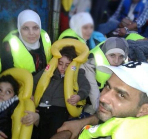 Sex personer med flytvästar på en flyktingbåt.