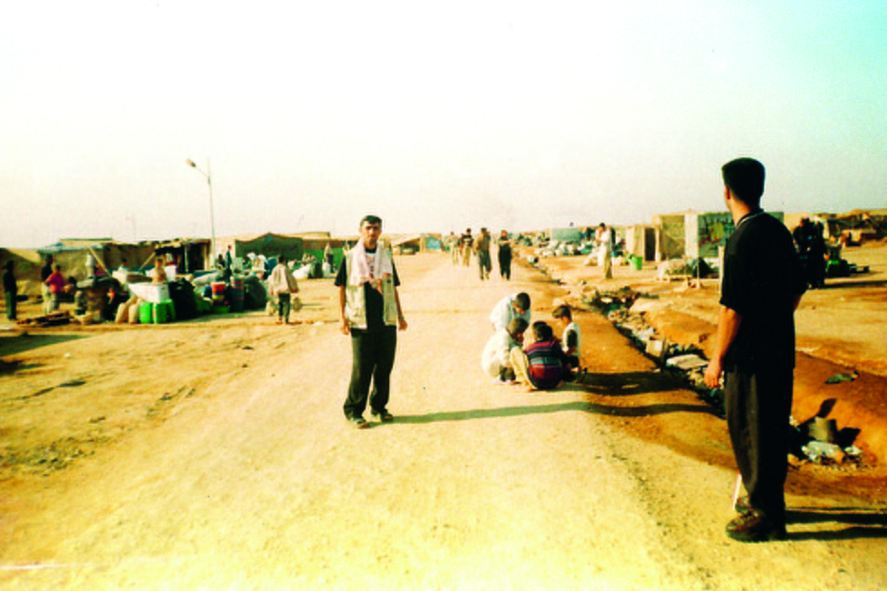 En man står på en väg i ett flyktingläger