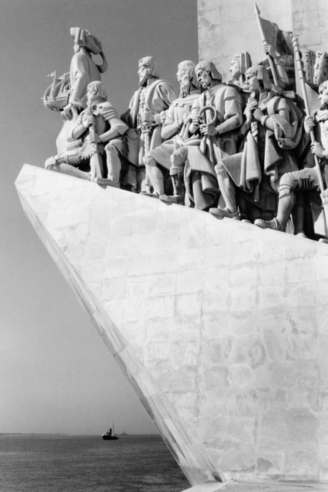 En gigantisk staty av en grupp män med fanor so går upp längs en sluttning. I bakgrunden breder havet ut sig.
