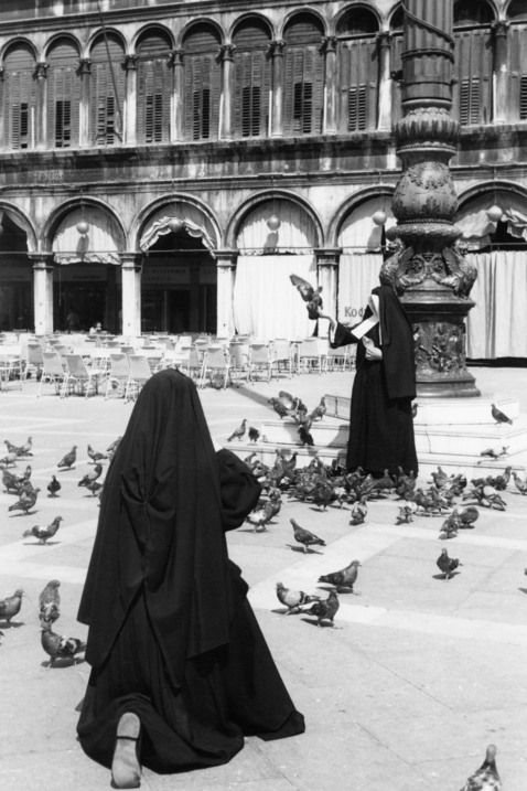 En kvinna med duvor på Piazzan S. Marco i Venedig.