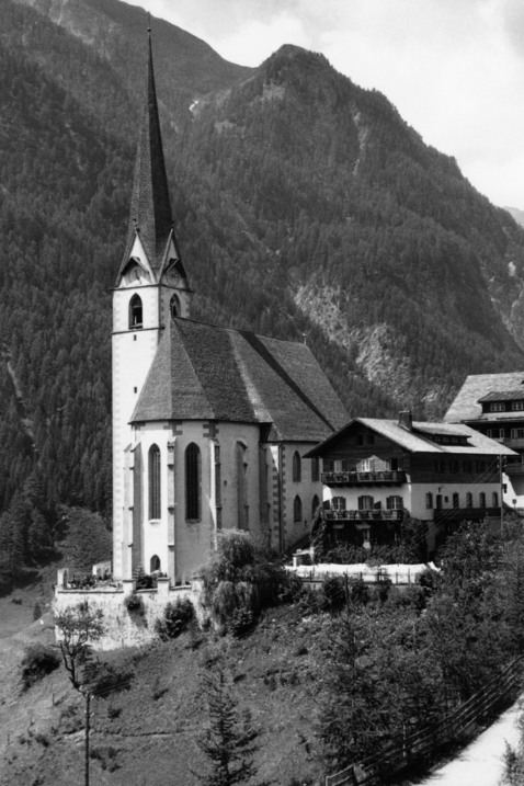 En mycket spetsig kyrka i ett skogigt bergslandskap