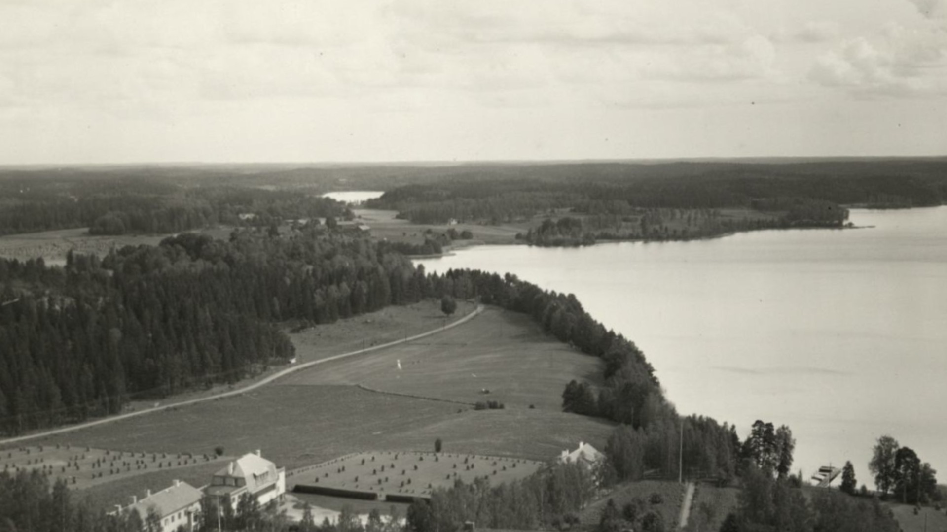 Flygfoto över Solbacka internatskolan; olika skolbyggnader syns, dessutom sjön Misteln