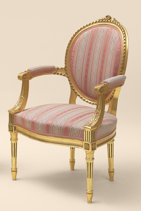 Foto på en förgylld karmstol med rosa textil.